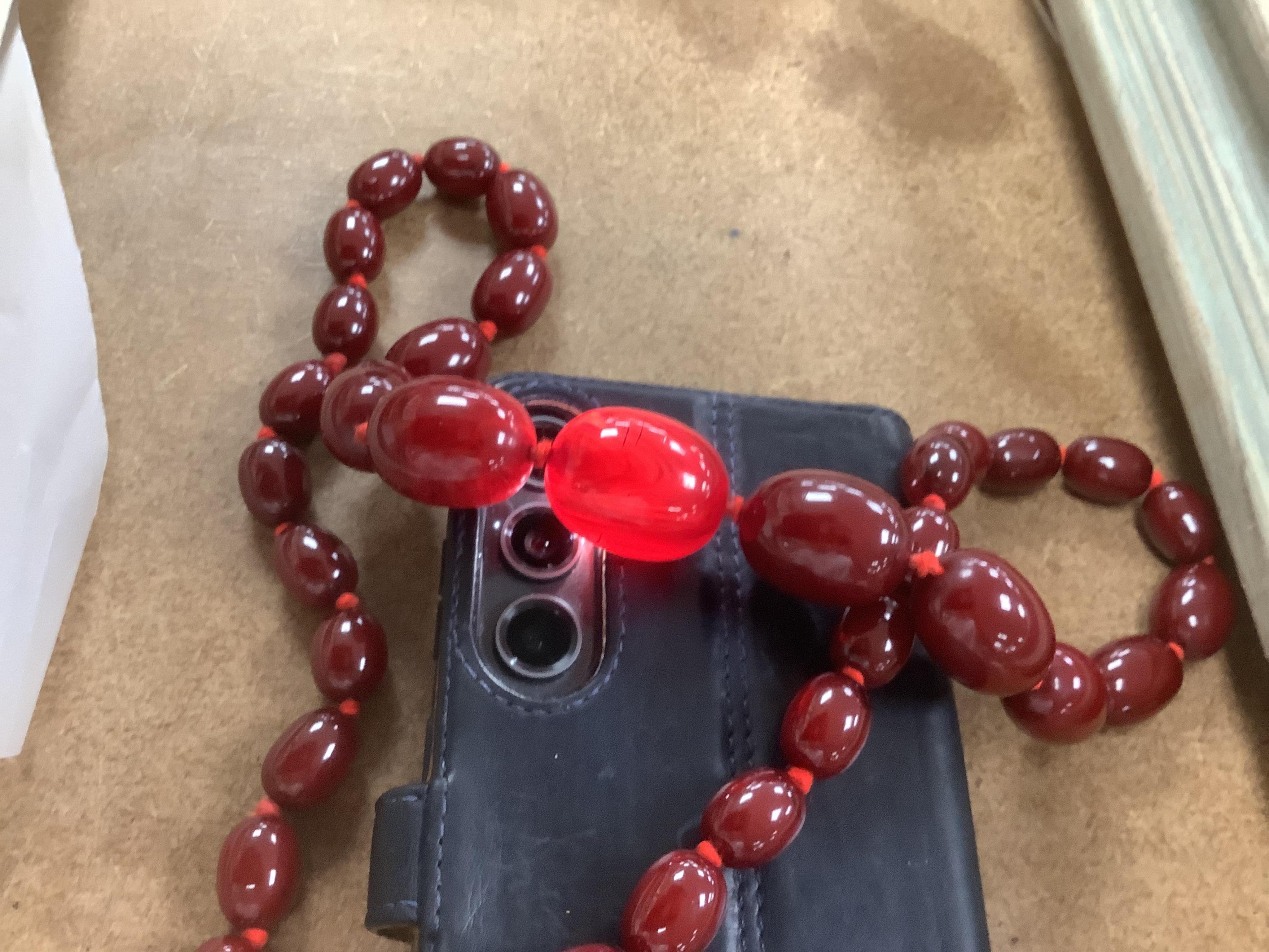 A single strand graduated simulated oval cherry amber bead necklace, 72cm, gross weight 100 grams.